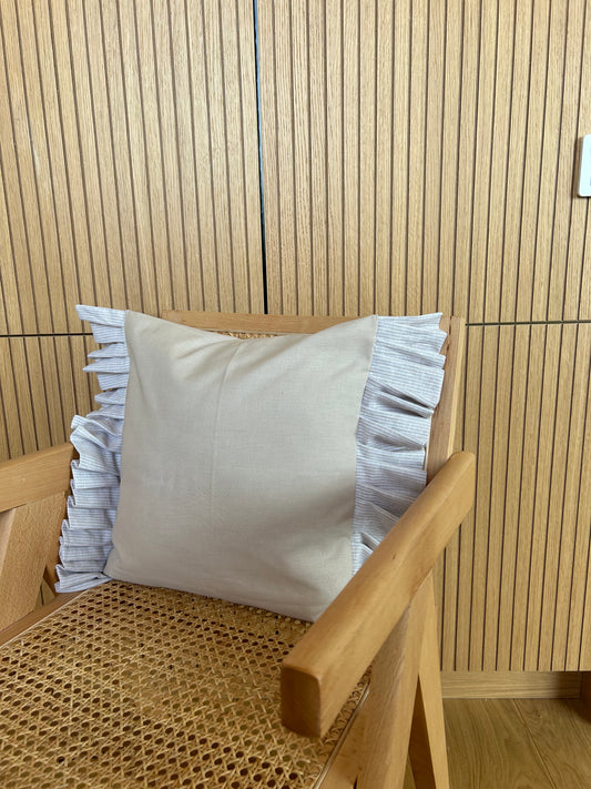 Cushion cover in a beige color with striped ruffles